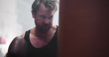 Male boxer punching a punch bag