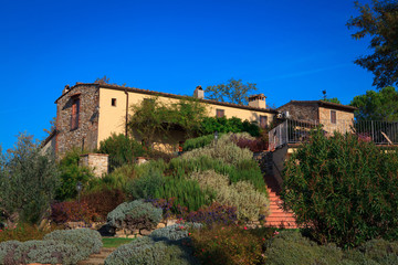 Fototapeta premium Typical Italian rural house with restaurant in lush vegetation in the afternoon in summer.