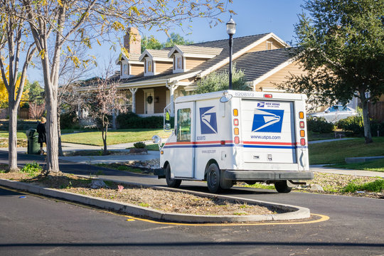 December 12, 2017 Livermore / CA / USA - USPS vehicle driving through a residential neighborhood on a sunny day