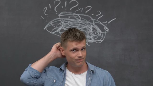 Puzzled young male scratching head having money shortage, unemployment, loan
