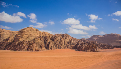 colorful picturesque desert scenic landscape view with sand valley and rocky mountain ridge background in Jordanian national heritage touristic destination site Wadi Rum  - obrazy, fototapety, plakaty