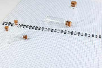 Medical Glass container with cork stopper are on the notebook.