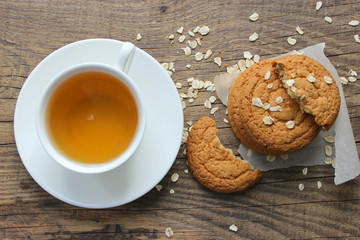 Homemade oatmeal cookies and a Cup of tea on an old wooden table, rustic style. Oatmeal and cinnamon sticks. Copy space.The view from the top.
