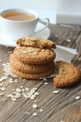 Homemade oatmeal cookies on an old wooden table, rustic style. Oatmeal and cinnamon sticks. Copy space.