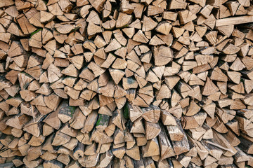 Dried wood for burning bonfire. Background of dry chopped wood folded for the fireplace. A pile of firewood for heating a house.