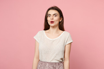 Amazed shocked young woman in casual light clothes posing isolated on pastel pink wall background, studio portrait. People sincere emotions lifestyle concept. Mock up copy space. Keeping mouth open.