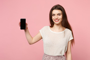 Smiling pretty young girl in casual light clothes posing isolated on pastel pink background studio...