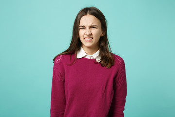 Fototapeta premium Young fun sad upset perplexed disturb brunette woman girl in red casual clothes posing isolated on blue wall background studio portrait. People sincere emotions lifestyle concept. Mock up copy space.