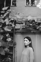 Young beautiful caucasian woman walking in old town. Black and white female art portrait.