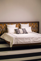 Modern stylish bedroom, double bed with headrest in the Art Nouveau style, retro, with a zigzag pattern, loft bedroom