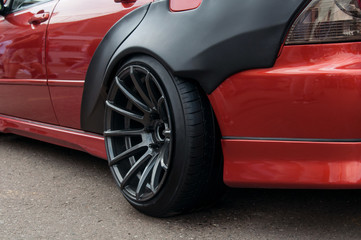 Fototapeta na wymiar black alloy wheels. racing red car. drift, sports car. extreme sport