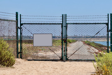 blank sign on chain link fence with gates 