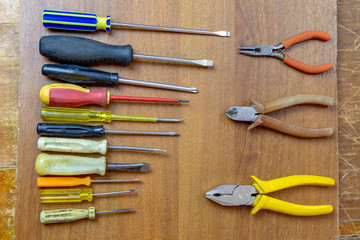 set of repair and craft tools on wooden background. Top view of pliers, hammer, screwdrivers.