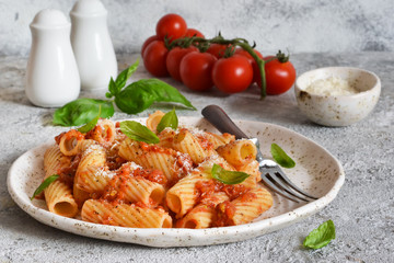 Pasta with tomato sauce and basil. Pasta tartilloni on a dark background.