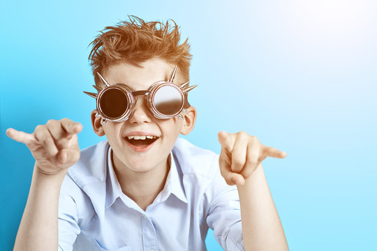 Rocker Boy In Blue Shirt And Biker Glasses On A Light Blue Background