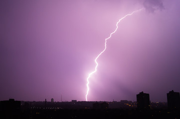  Lightning flashes over the night city. Discharge of electricity in the night sky.