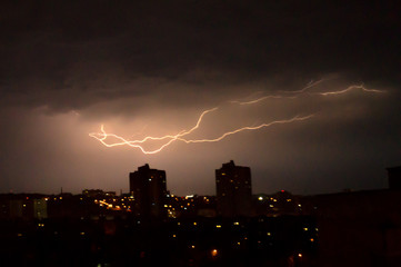  Lightning flashes over the night city. Discharge of electricity in the night sky.