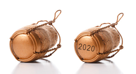 Closeup of two champagne corks with their cage on white with reflection