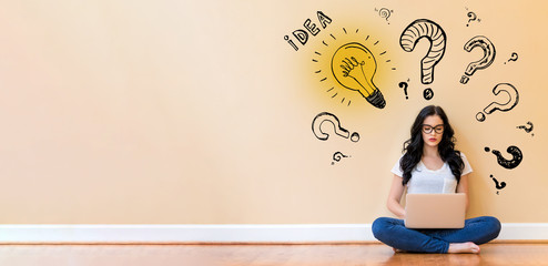 Idea light bulbs with question marks with young woman using a laptop computer