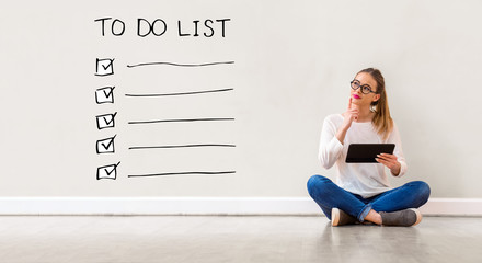 To do list with young woman holding a tablet computer - obrazy, fototapety, plakaty