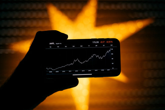 PARIS, FRANCE - NOV 10 2017: Man Holding New Apple IPhone X 10 Smartphone With Stock App Showing The Latest Share Price And Graph Of The Apple Stock Quotation