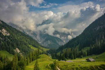 clouds around peaks of Reither Alpe mountains with Bindalm in the front, Berchtesgaden national park, Bavaria, Germany