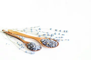 Fototapeten Wooden spoons with dried lavender blossoms and bouquet with lavender on white background © isavira