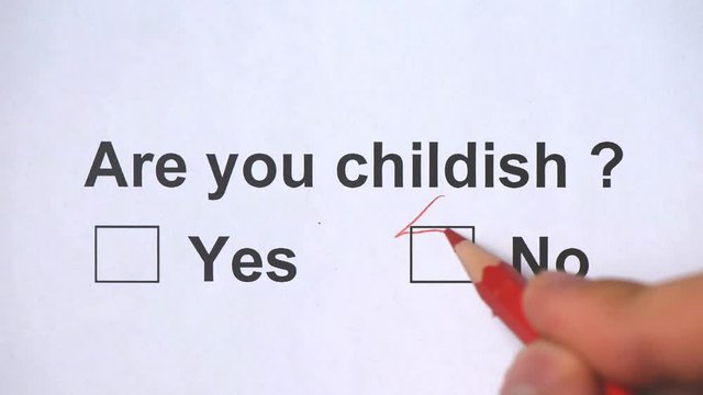 Overhead shot of a caucasian man answering to the question: Are you childish? on the white piece of sheets