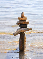The stones are balanced on the sea. Stone towers on a sunny day.