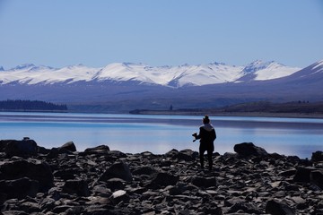 LAKE TEKAPO, CANTERBURY, NEW ZEALAND, SEPTEMBER 21, Young photographer getting into position by the lake on September 21, 2015