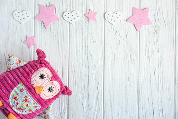 Design greeting card for girls. Toy owl and butterflies on a wooden background. Frame for greeting card text. It's a girl