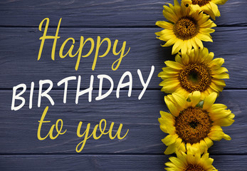 Happy Birthday to You. Birthday greeting card with flowers on a wooden background. Greeting card for girls, congratulations on mother's day. View from above