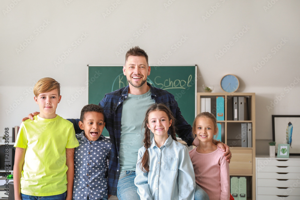 Wall mural Cute children with teacher in classroom