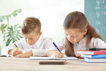 Fototapeta na wymiar Little pupils doing lessons in classroom