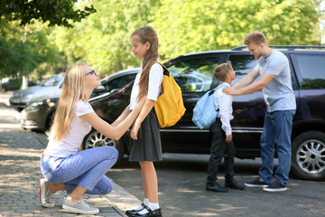 Fototapeta premium Parents saying goodbye to their children near school