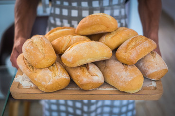Bakery and fresh ready made bread concept - adult man standing with food - atisan work and worker - healthy lifestyle and alternative job lifestyle