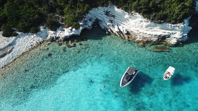 Aerial drone photo of tropical paradise turquoise beach of Voutoumi with sail boats docked in island of Antipaxos, Ionian, Greece