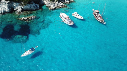 Aerial drone photo of tropical paradise turquoise beach of Voutoumi with sail boats docked in island of Antipaxos, Ionian, Greece