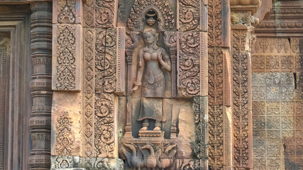 bas relief of a devata in a niche at banteay srei, angkor