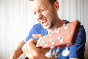 close-up of a young man playing the guitar and singing