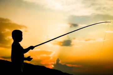 happy child fishing by the sea silhouette