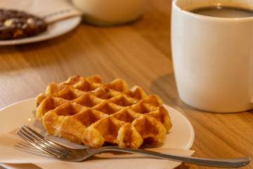 Belgian waffles, cup of coffee on wooden background. 