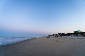 twilight's first gleaming on the beach of the outer banks of north carolina. a waxing quarter moon...