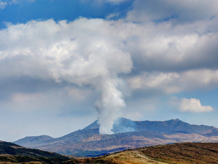 Fototapeta na wymiar Japan's active volcano Mount Aso erupting with white smoke