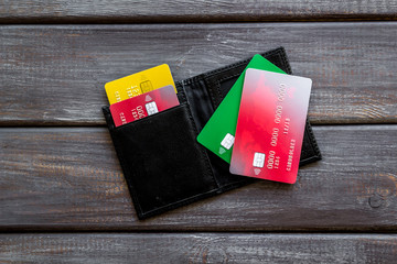 Bank card, debit, credit in wallet on wooden background top view