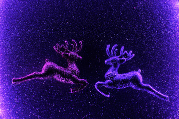 Obraz na płótnie Canvas Christmas glitter deer on violet sparkling background. Neon light. Christmas concept.