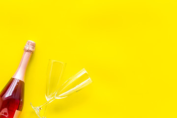 Party with champagne bottle and glasses on yellow background top view space for text