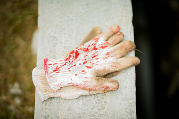 Meat gloves with blood stains on the concrete.