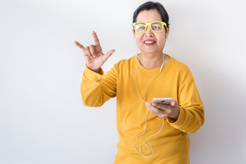 Senior asian woman listening to music with earphone,Elderly female using smartphone feeling funny...