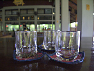 The glass is placed on the tray on the table in the restaurant, Selective focus, Blurred.